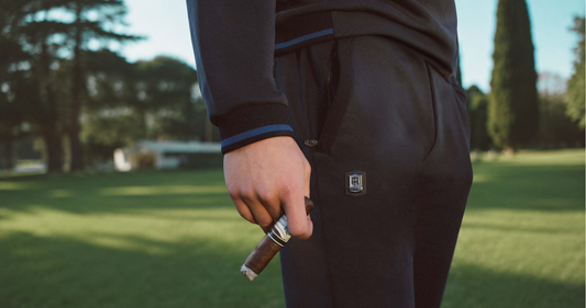 Close-up of black THEODORE luxury trousers with signature crest detail, highlighting tailored fit, refined finishing, and Smart Luxury menswear.