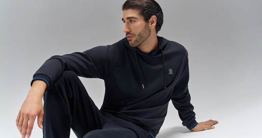 Men’s luxury athleisure outfit with zip hoodie and trousers styled in modern minimalist editorial setting